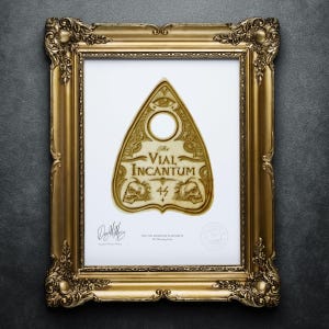 May include: A framed print of a vintage-style Ouija board planchette with the text "The Vial Incantum 44" in a gold frame. The print is signed by the artist and includes a seal.