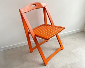 Vintage orange wooden folding chair with a slat seat