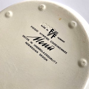 Pu&ograve; includere: Piatto in ceramica bianca con testo nero che recita "Made in Norway, Figgjo Vitrified Cookingware, Decor in Underglazequality Norwegian Design, Menu, FF".