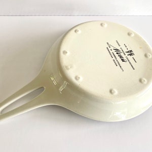 Pu&ograve; includere: Padella in ceramica bianca con manico nero e il testo "Menu" in lettere nere. La padella &egrave; contrassegnata con "Food Vitrified Cookware" e "Decor in Undersalability Norwegian Design".