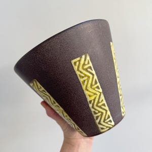 May include: A set of three ceramic mugs with a speckled, matte finish. The mugs are in shades of cream, light gray, and dark gray. Each mug has a simple, minimalist design, perfect for coffee or tea.