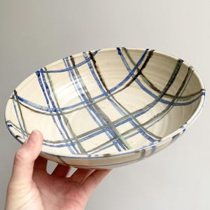 May include: A set of three ceramic mugs with a speckled, matte finish. The mugs are in shades of cream, light gray, and dark gray. Each mug has a simple, minimalist design, perfect for coffee or tea.
