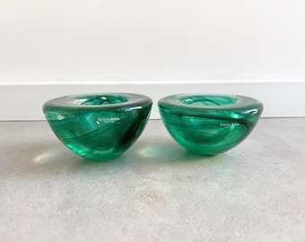 May include: Two green glass candle holders with a swirl design. The holders are made by Kosta Boda.
