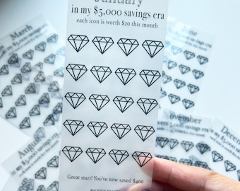 May include: Clear sticker sheet with diamond icons for savings tracking. The sheet reads "January in my $5,000 savings era" and "each icon is worth $20 this month." The text "Great start! You've now saved $400" is also visible.