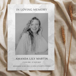 May include: A memorial card with the text "IN LOVING MEMORY" at the top. A black and white photo of a smiling woman is in the center. The name "AMANDA LILY MARTIN" is below the photo, along with dates and a church name.