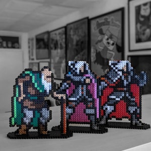 May include: Three pixel art figures made of beads. The figures are a green and brown warrior, a purple and gray knight, and a red and gray knight. The figures are standing on black bases.