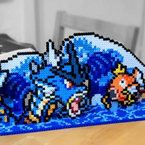 Könnte beinhalten: Eine blaue und weiße Pixel-Art-Kreation eines Wasser-Pokémon, mit einem kleineren orangefarbenen und gelben Fisch-Pokémon im Hintergrund.
