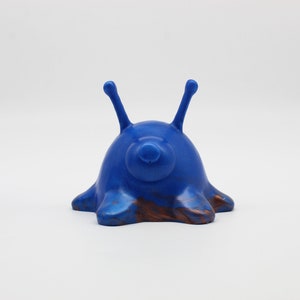 May include: A blue and brown ceramic figurine of a creature with two long antennae and a rounded body.
