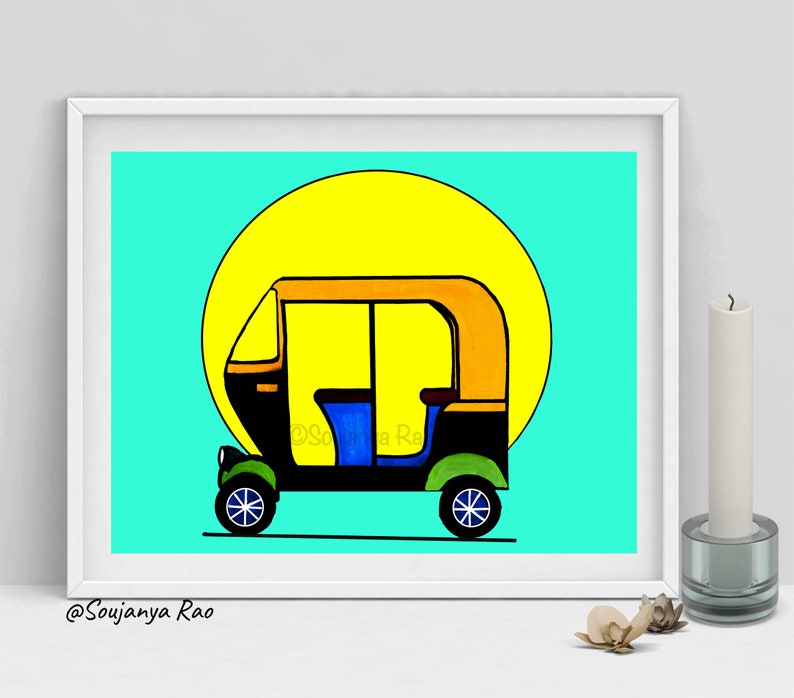 May include: A framed art print featuring a colorful illustration of an auto rickshaw, set against a bright yellow sun and a turquoise background. The auto rickshaw is black, yellow, blue, and green. The artist's name, Soujanya Rao, is in the bottom left corner.