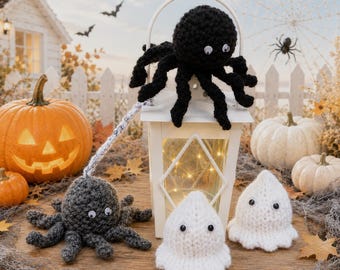May include: A white lantern topped with a black crocheted spider with googly eyes. A second grey crocheted spider is attached by a white yarn strand. Two small white crocheted ghosts with googly eyes sit in front of the lantern on a wooden surface.
