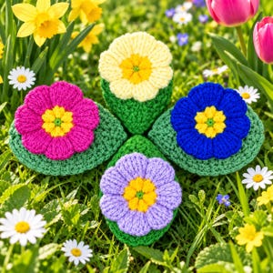 May include: Four crocheted flowers with green leaves arranged in a diamond pattern. The flowers are yellow, hot pink, royal blue, and light purple, each featuring a textured yellow centre. The petals are rounded and stitched with yarn.