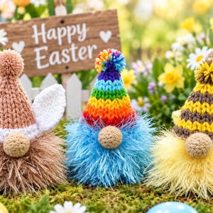 May include: Three handcrafted gnomes featuring textured faux fur bodies and knit hats. The left gnome has a tan hat with white ears, the centre has a rainbow striped hat, and the right has a yellow and brown striped hat with yellow wings.