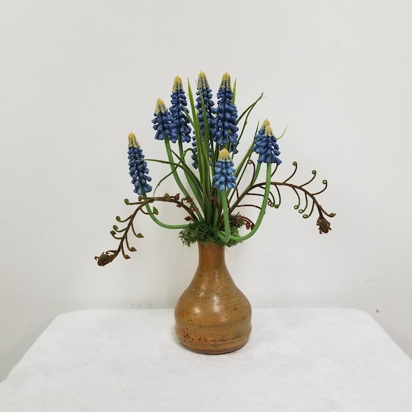 Faux purple Grape Hyacinth plants, Faux fern stems, and Deer moss, potted in a bud vase clay pot, clear glazed.