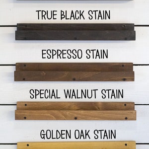 May include: Five wooden shelves stained in different colors, including weathered gray, true black, espresso, special walnut, and golden oak. Each shelf is labeled with the stain color.