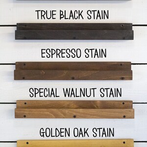 May include: Five wooden shelves stained in different colors, including weathered gray, true black, espresso, special walnut, and golden oak. Each shelf is labeled with the stain color.