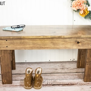 May include: A wooden bench with a natural stain finish. The bench has a simple design with four legs and a flat top. The bench is sitting on a wooden floor. The text "SPECIAL WALNUT" is visible in the top left corner of the image.