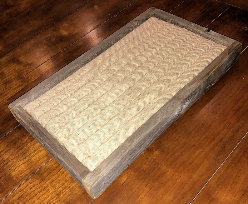May include: A rectangular wooden tray with a burlap lining. The tray has a rustic, weathered look and is perfect for displaying small items.