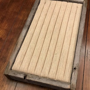 May include: A rustic wooden frame with a burlap fabric insert. The frame has a distressed gray finish and is perfect for displaying small items.