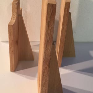 May include: Three wooden picture frames, each with a different size and shape. The frames are made of natural wood and have a rustic look.
