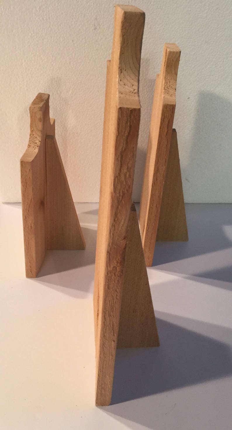 May include: Three wooden picture frames, each with a different size and shape. The frames are made of natural wood and have a rustic look.