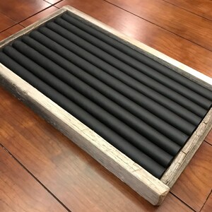 May include: A wooden ring holder with a black felt lining. The holder has 10 slots for rings.