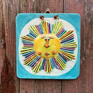 Hangable rainbow sun face tile, handmade ceramic nursery plaque, home/garden decor, playful garden ornament, outdoor patio wall art