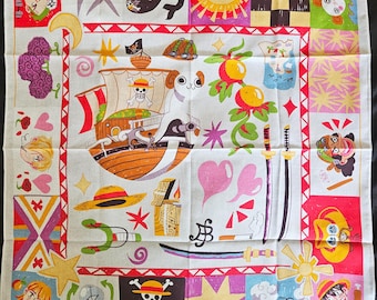 May include: Square white handkerchief with colorful cartoon illustrations. Features a pirate ship, swords, and various character portraits. The border has a red and white striped design, with a variety of other images.