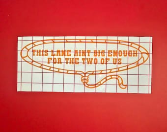May include: Orange vinyl decal with a lasso design and the text "This lane ain't big enough for the two of us".