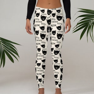 May include: Black and white leggings with a repeating pattern of black cat faces and the text "Kitty Takeover Meow".