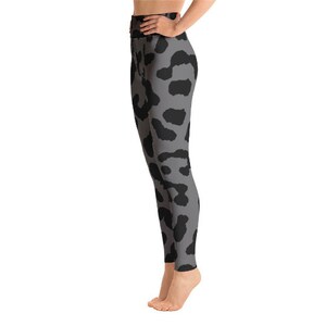 May include: Gray leggings with a black animal print pattern. The leggings are high-waisted and form-fitting, made of a stretchy material. The black spots are irregularly shaped and distributed across the gray background.