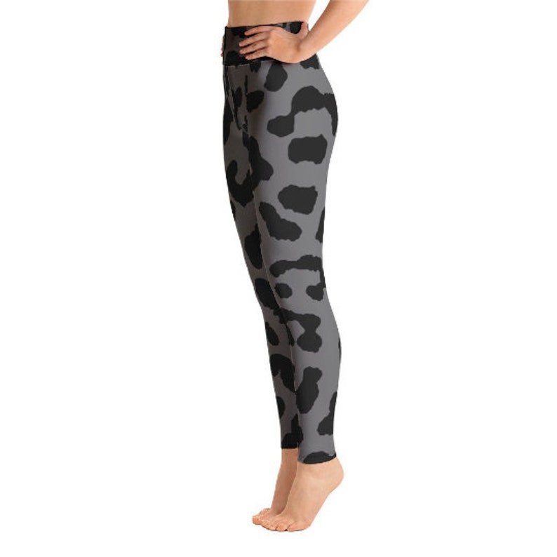 May include: Gray leggings with a black animal print pattern. The leggings are high-waisted and form-fitting, made of a stretchy material. The black spots are irregularly shaped and distributed across the gray background.