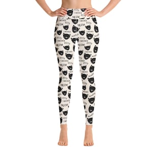 May include: Black and white leggings with a repeating pattern of black cats and the text "Kitty Takeover Meow".