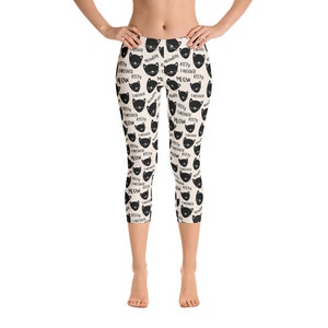 May include: Black and white leggings with a repeating pattern of black cat faces and the text "Kitty Takeover Meow".