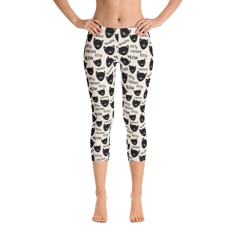 May include: Black and white leggings with a repeating pattern of black cat faces and the text "Kitty Takeover Meow".