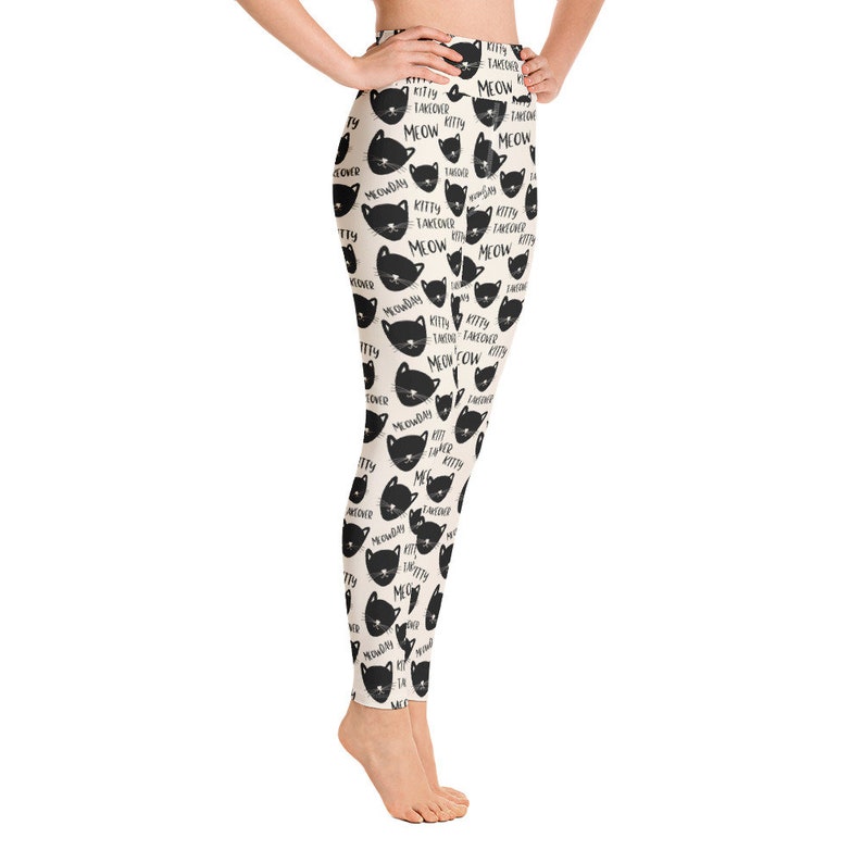 May include: Black and white leggings with a repeating pattern of black cat faces and the text "Kitty Takeover Meow" on a cream background.