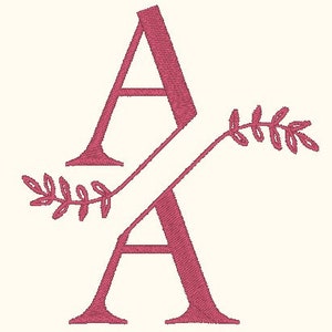 Op de afbeelding: Een roze monogram-initiaal "A" met een gestileerd bloemmotief. De letter wordt twee keer herhaald, waarbij de tweede letter de eerste overlapt.