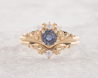 Puede incluir: Un anillo de oro engastado con un zafiro azul y pequeños diamantes. El anillo presenta un delicado diseño floral.