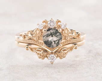 May include: A gold ring set with a green and black agate gemstone surrounded by small diamonds. The ring features a delicate floral design.