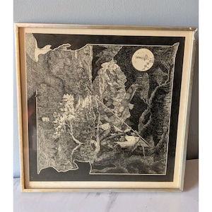 May include: Framed black and white artwork featuring a detailed landscape with a full moon, trees, and a figure. The artwork is in a silver frame, creating a striking contrast with the dark imagery. The style appears to be an intricate pen and ink drawing.