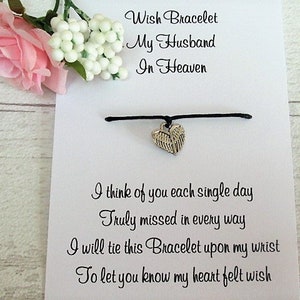 May include: A white card with black text that reads "Wish Bracelet My Husband In Heaven" and "I think of you each single day Truly missed in every way I will tie this Bracelet upon my wrist To let you know my heart felt wish". A black string bracelet with a silver angel wing charm is attached to the card.