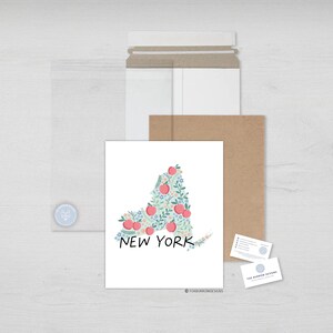 May include: A white card with a floral design of the state of New York. The state is outlined in green and filled with pink apples and blue flowers. The text "NEW YORK" is written in black below the state.