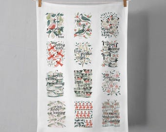 May include: A white tea towel with a colorful illustration of the 12 Days of Christmas. Each day is depicted with a different image and the corresponding verse from the song. The illustration is in a vintage style with a whimsical feel.