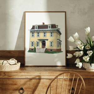 May include: A framed illustration of a yellow two-storey house with a brown roof and white trim. The house has a front porch with a white railing and a green lawn.