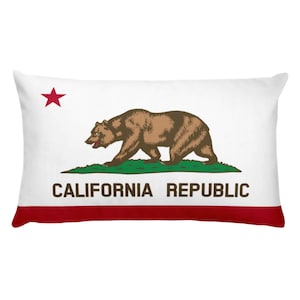 May include: A white rectangular pillow with a red star, a brown bear walking on green grass, and the text "CALIFORNIA REPUBLIC" in brown letters. The pillow has a red border.