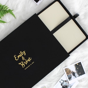 Puede incluir: Caja negra con interior de cuero blanco. La caja está grabada con el texto "Emily & Brent, February 11, 2018".
