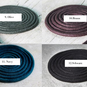 May include: Four coils of braided rope arranged in a grid. Each coil is labelled with a white rectangular tag: 9. Olive, 10. Braun, 11. Navy, and 12. Schwarz. The ropes feature a textured, woven surface and are displayed in olive, brown, navy blue, and black.