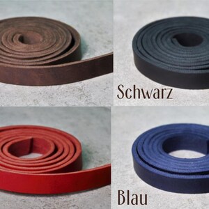 Peut inclure: Huit bandes de cuir enroul&eacute;es dans des couleurs vari&eacute;es : cognac, marron, noir, rose, gris, rouge, bleu et vert. Chaque bobine est &eacute;tiquet&eacute;e avec son nom de couleur en allemand sous la bande, pr&eacute;sentant une texture plate et lisse.