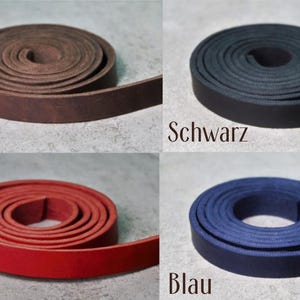 Pode incluir: Oito tiras de couro enroladas em v&aacute;rias cores: conhaque, castanho, preto, rosa, cinzento, vermelho, azul e verde. Cada bobina est&aacute; etiquetada com o nome da cor correspondente em alem&atilde;o sob a tira, exibindo uma textura plana e lisa.