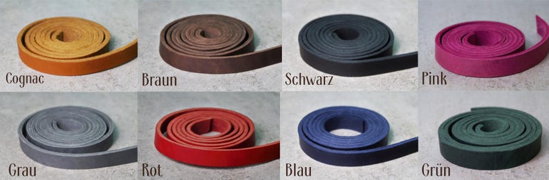 Pode incluir: Oito tiras de couro enroladas em v&aacute;rias cores: conhaque, castanho, preto, rosa, cinzento, vermelho, azul e verde. Cada bobina est&aacute; etiquetada com o nome da cor correspondente em alem&atilde;o sob a tira, exibindo uma textura plana e lisa.