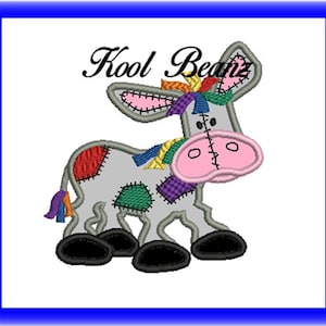 Op de afbeelding: Een grijze patchwork-ezel met een roze neus en een regenboogkleurige manen. De ezel staat op alle vier poten en heeft een zwarte staart.